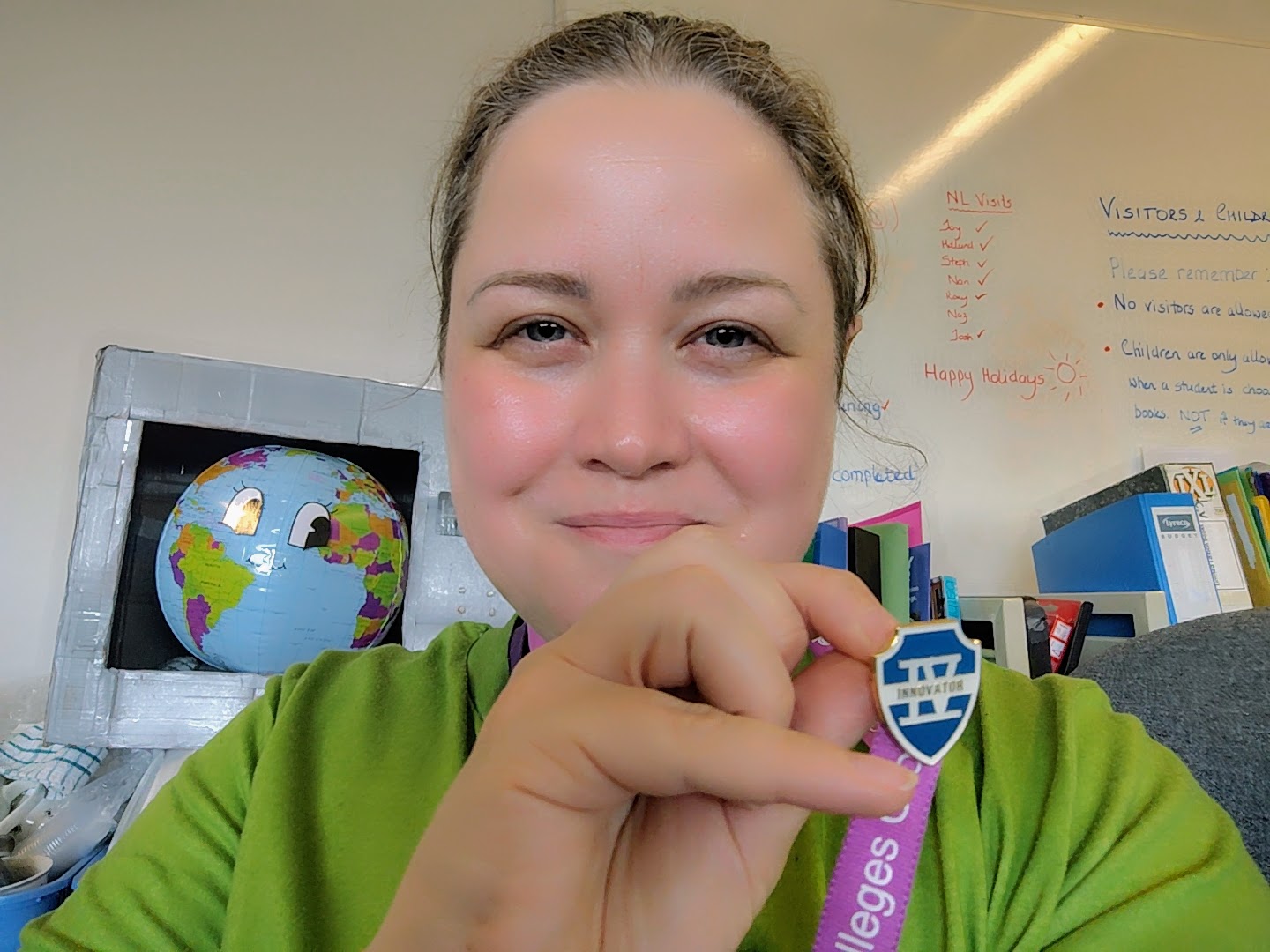 A person smiling and showing a blue badge